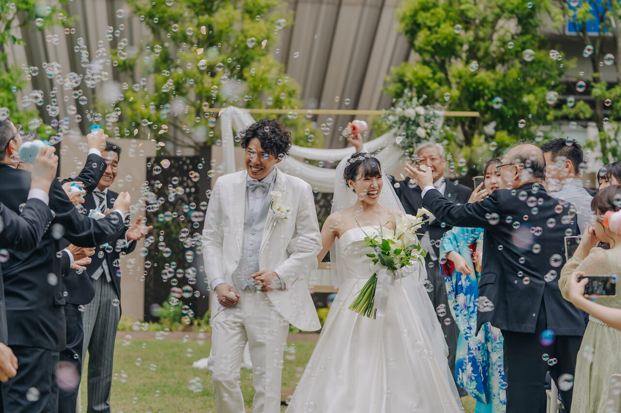 シャボン玉シャワーで祝福される新郎新婦